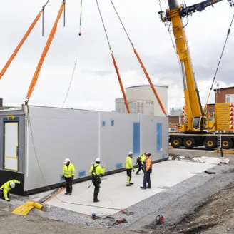 Construction workers installing a power center module